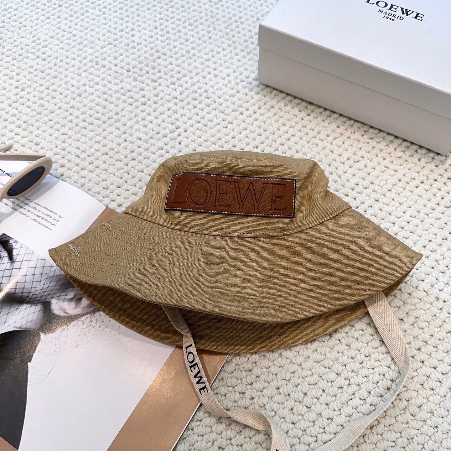Soft canvas bucket hat with embossed leather logo patch and adjustable chin strap